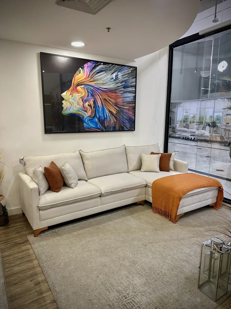 Sofá claro de canto com chaise e almofadas em sala decorada